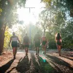 Five travellers walk along a sunlit forest trail on the Fully Guided Ultimate East Coast Sydney to Cairns 6 Weeks 2 adventure tour.