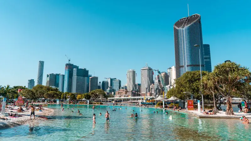 Travellers enjoy swimming and sunbathing at a vibrant city beach on the top-rated Fully Guided Ultimate East Coast Melbourne to Cairns tour.