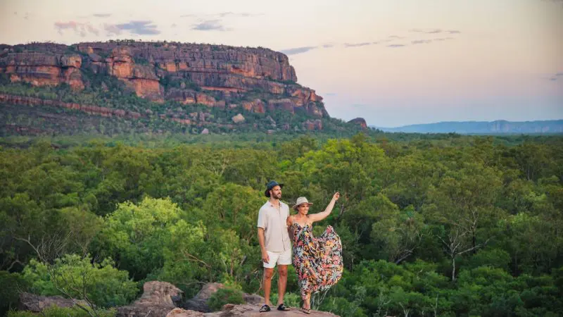 A couple explores rocky terrain at sunset on a 5 Day Kakadu, Katherine Gorge & Litchfield 4WD Adventure departing from Darwin.