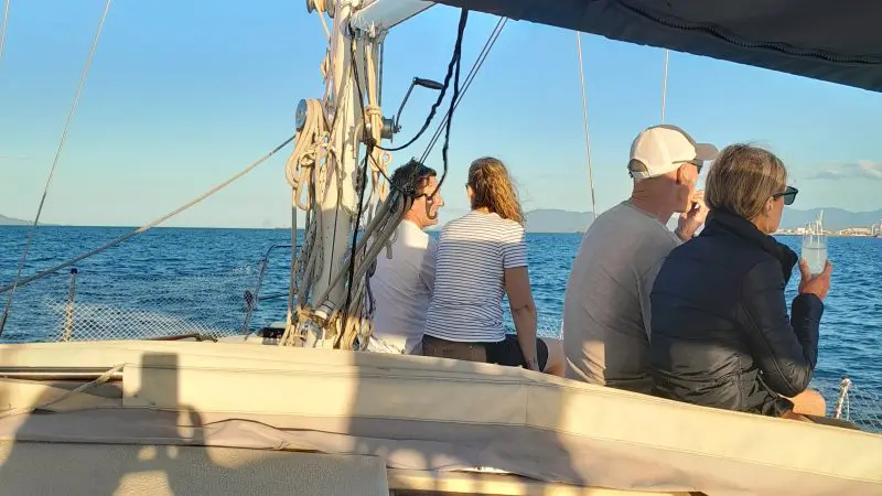 Group of four enjoying a Townsville Lunchtime Sailing Private Charter, taking in stunning ocean views under a vibrant blue canopy.