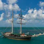 Experience the iconic Solway Lass: a majestic tall black ship cruising Whitsunday’s turquoise waters for 3 days, 2 nights under blue skies.