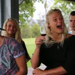 Four young adults savour red wine outdoors on a 1 Day Hunter Valley Wineries Tour from Sydney with Colourful Collective Travel.