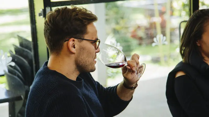 Traveller savouring premium red wine indoors during a luxury 1 Day Hunter Valley Wineries Tour from Sydney by Colourful Collective Travel.