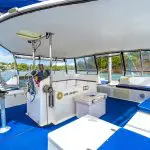 Stunning catamaran interior for Sydney Harbour BYO Vivid Lights cruise, featuring vibrant blue floors, comfortable seating, and panoramic water views.