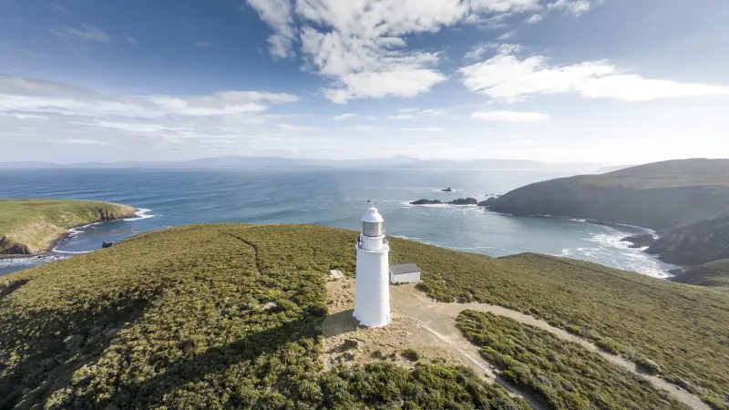 Iconic white lighthouse set on lush green Bruny Island coast, featured in Cape Bruny Lighthouse and Food Sightseeing Tours, Tasmania.