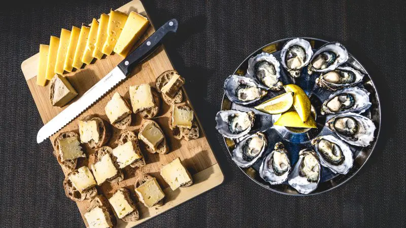 Platter with fresh oysters, gourmet cheese, artisan bread on Bruny Island Food Tour near Cape Bruny Lighthouse—Tasmania’s top food experience.