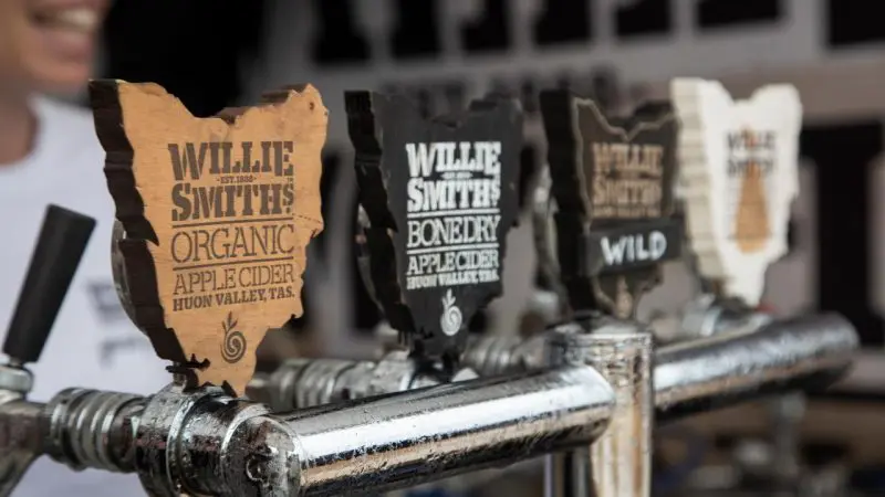 Willie Smith’s cider taps showcased on Huon Valley Safaris Private Day Tour, lined up on a gleaming cider bar stand.