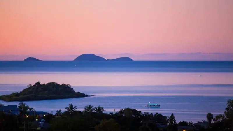 Serene sunset ocean with tranquil islands, ideal for a Sundowner Sunset Cruise past silhouetted trees and scenic coastal landmarks.