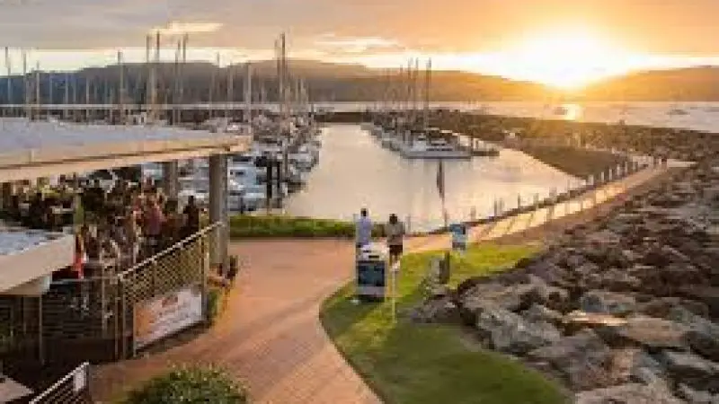 Guests savour a Sundowner Cruise and Dine near Sorrentos Restaurant, with yachts lining the vibrant marina at sunset for a scenic view.