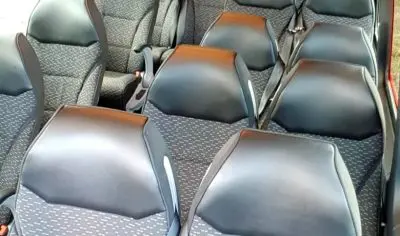 Spacious, well-lit minibus with rows of empty black and grey seats—ideal group transport for scenic Christchurch or Lake Tekapo trips.