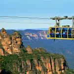 Experience breath-taking views as a yellow and blue cable car soars above the stunning Blue Mountains canyon on a signature day tour.