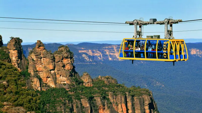 Experience breath-taking views as a yellow and blue cable car soars above the stunning Blue Mountains canyon on a signature day tour.