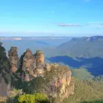 The iconic Three Sisters rock formations rise above a lush Blue Mountains valley on a guided tour with scenic waterfall walk and lunch.
