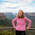 Happy woman in a red striped top admires scenic Blue Mountains views on exclusive 1 Day Wildlife Park Trip, perfect for travel seekers.