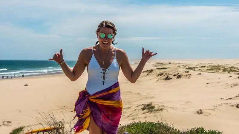 Smiling woman in sunglasses and swimming costume flashes shaka signs on a 1 Day Whale Watching Port Stephens tour, enjoying the adventure.