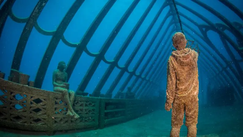 Stunning underwater human sculptures within a sunken ship on the Great Barrier Reef Moua, captured during an unforgettable day trip.