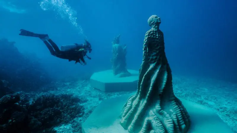 Scuba diver discovers unique underwater statues near the Great Barrier Reef on a Moua tour from Townsville and Magnetic Island.
