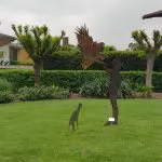 Striking metal sculptures of a person, bird, and dog grace lush green lawns—ideal photo spot during your Yarra Valley wine tasting tour.
