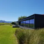 Contemporary winery with expansive glass windows offers panoramic views over lush Yarra Valley vineyards, ideal for top wine tasting.