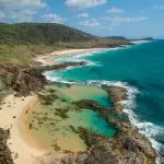 Stunning aerial of Kgari 5 Day Ultimate coastline with crystal-clear turquoise waters, pristine sandy beach, and scenic natural rock pools.