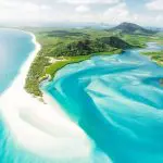 Stunning aerial view of a tropical coastline with clear blue skies, ideal for an East Coast Explorer or 27-day adventure tour.