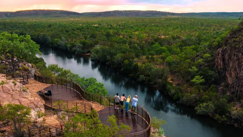 Group of four enjoying vibrant sunset vistas over Katherine Gorge’s lush river and rocks on a top-rated day cruise from Darwin.