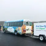 Great Ocean Road and Beyond 4 Day 3 Night Tour coach and trailer parked, branding visible, man standing beside for travel adventure.
