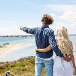 A couple stands by Margaret River’s scenic seaside as the man points at the ocean, ready for a thrilling wildlife adventure.