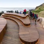 Serpentine wooden boardwalk with visitors admiring stunning ocean views on the Phillip Island Penguin Parade and Koalas tour day trip.