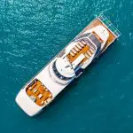 Aerial photo of a luxurious white yacht with brown decks at Whitehaven Beach, showcased all day; no snorkelling permitted on-site.