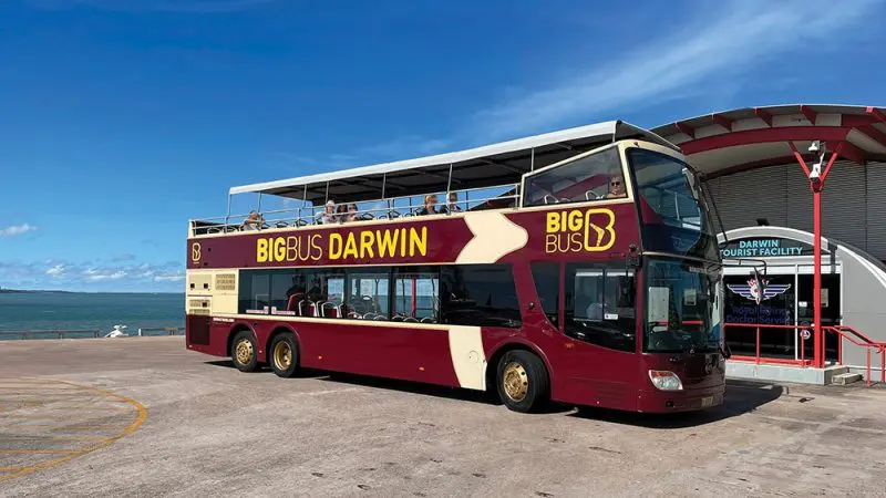 Maroon and yellow Croc Explorer Ticket Big Bus Darwin by the ocean at Darwin Tourist Facility, perfect for scenic city sightseeing tours.