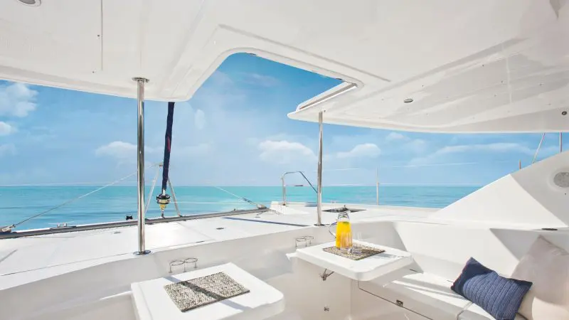 Opulent Whitehaven Dreamer yacht deck set for 2Day 2Night Whitsunday Sailing, with plush cushions, cocktails, and panoramic sea views.