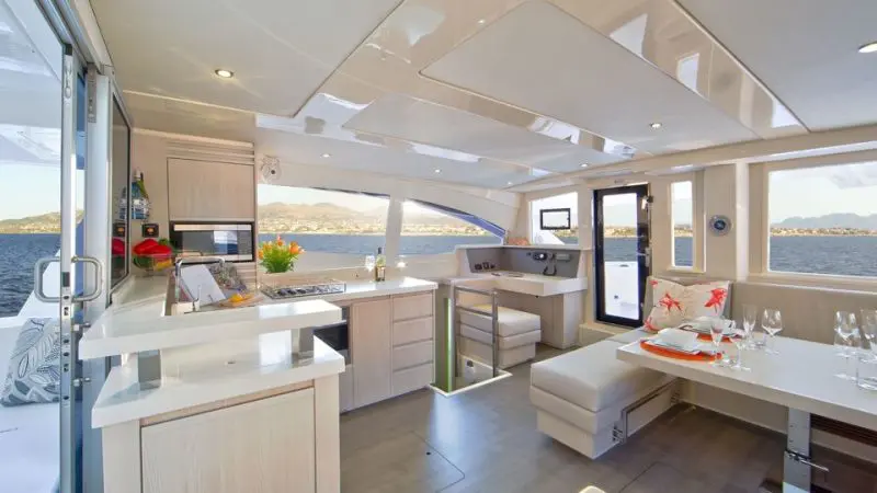 Luxurious Whitehaven Dreamer yacht interior featuring gourmet kitchen, elegant dining area, and panoramic windows with Whitsunday views.