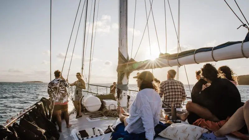 Guests unwind aboard a luxurious Summer Jo Day Charter sailboat at sunset, surrounded by breathtaking panoramic ocean views.