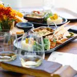 Elegant table featuring gourmet appetisers, artisan bread, fine wine glasses, and fresh flowers at a luxury boutique wine tasting tour.
