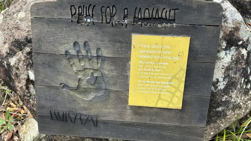 Wooden sign with handprint and plaque invites visitors to honour Indigenous ancestors at Hook Island’s renowned cultural snorkelling site.