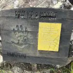 Hook Island cultural legacy sign: wooden board with handprint, engraved lettering, yellow plaque highlighting island heritage.