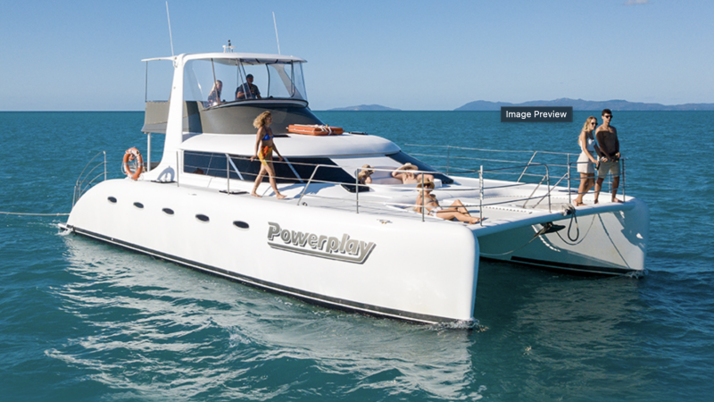 a luxury catamaran in the ocean with people sitting at the front