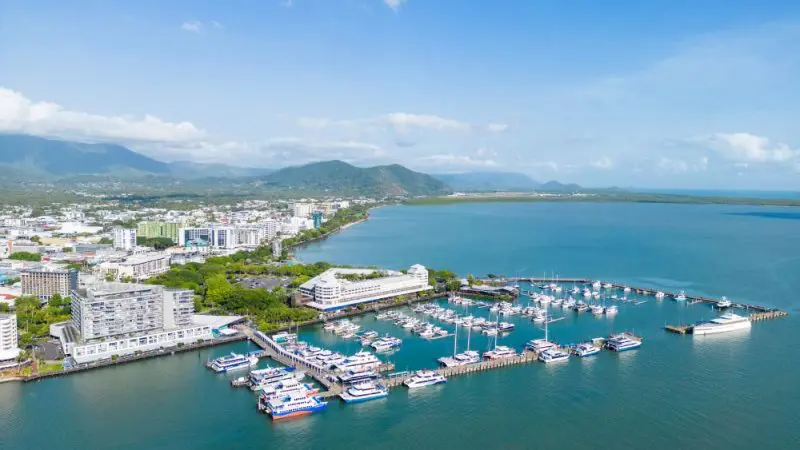 Stunning aerial view of Cairns marina with yachts, city skyline, ideal for City Sights tours or Dinner Cruise with Palm Cove Pick-up.