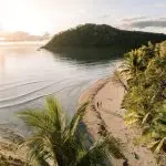 Breathtaking aerial view of a golden tropical beach at sunset, ideal for a 16-Day East Coast Australia Tour from Sydney.