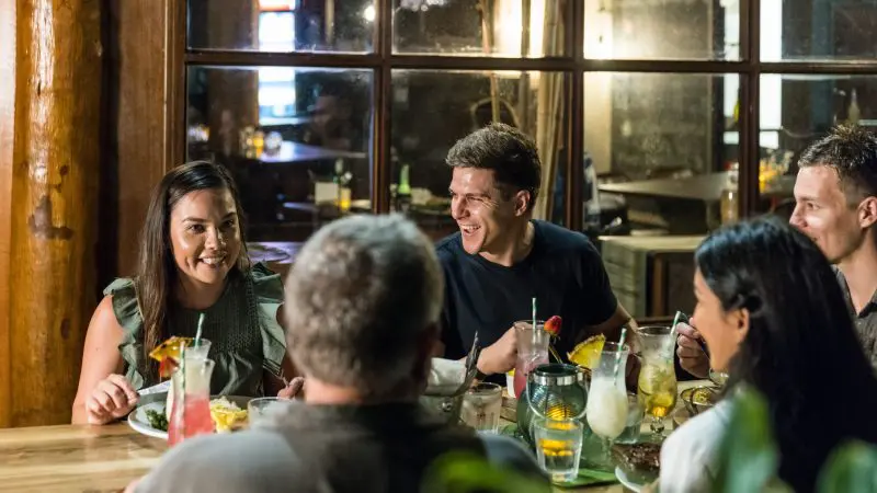 Five travellers savour drinks and cuisine, exchanging stories from a 3-Day Daintree Cape Tribulation Port Douglas Comfort Tour experience.