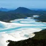 Spectacular aerial view of vibrant turquoise waters weaving through pristine white sands on a Sydney to Cairns, Fraser Island tour.
