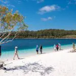 Travellers enjoy a scenic walk on pristine white sands during the 16-Day Best of East Coast Australia Comfort Tour from Sydney.