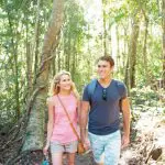 A joyful couple walk hand in hand along a sunlit trail on their 8-day Sydney to Brisbane with Fraser Island Comfort Tour adventure.