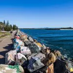 Scenic seafront walkway with colourful painted rocks on the 14 Day Sydney to Cairns, Fraser Island & Whitsundays Comfort Tour route.
