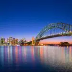 Experience Sydney Harbour Bridge at dusk, city shimmering—begin your 8-Day Sydney to Brisbane and Fraser Island Comfort Tour.