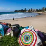 Vividly painted rocks line a sandy beach on the 8 Day Sydney to Brisbane With Fraser Island Comfort Tour, Australia coastal scenery.