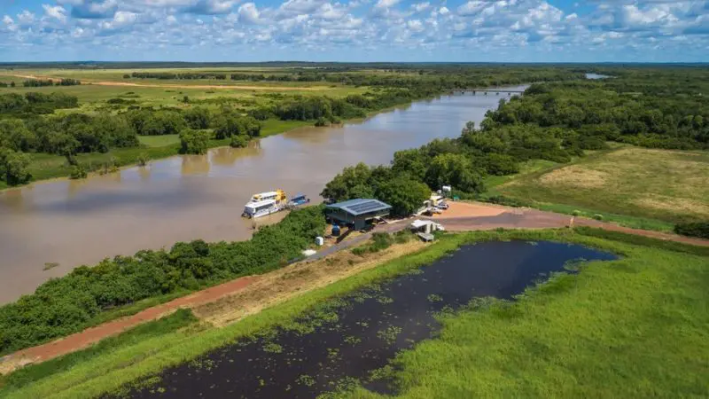 Stunning aerial view of a river, boats, and dock, capturing the excitement of a Kakadu Wilderness Escape and Crocodile Cruise adventure.
