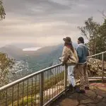 Two adventurers enjoy breathtaking mountain and valley river vistas on a 1 Day Grampians Eco Wilderness Escape in Australia.