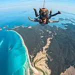 Experience an epic tandem skydive over Whitehaven Beach, captured in HD video and photos—fly above turquoise waters, sandy shores, lush islands.